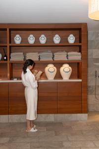 a woman standing in front of a shelf with vases at Waldhotel by Bürgenstock in Bürgenstock +103 photos