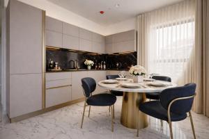a kitchen with a round table and chairs at IsLe Royal Suites By Mercury Tower in St. Julianʼs