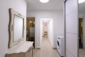 a white bathroom with a sink and a mirror at אירוח תמר in Qiryat Shemona +27 photos