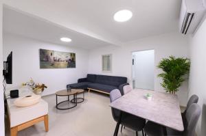 a living room with a blue couch and a table at אירוח תמר in Qiryat Shemona