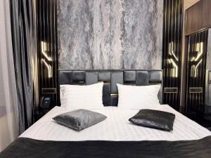 a bedroom with a bed with two pillows on it at Gyumri Moderna in Gyumri