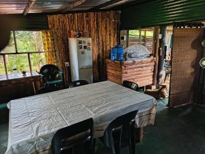 a kitchen with a table and chairs and a refrigerator at Joy River Backpackers in Moremela
