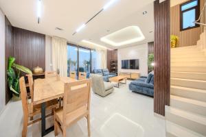 a living room with a wooden dining room table at 3BR Amazing Villa - Private Pool - 3WC - BBQ Pit in Sharjah