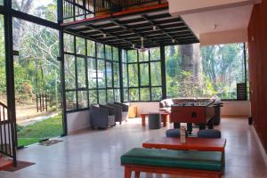 a large room with large windows and a table at Coorg Homes in Madikeri