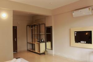 a living room with a tv on a wall at Coorg Homes in Madikeri