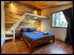 a bedroom with a bed with a wooden wall at gite comme un accord in Saint Mathieu Du Parc