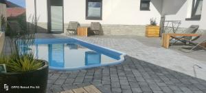 a blue pool in a patio with a table and chairs at APART 558 Szczyrk, Ski&Bike, basen, blisko wyciągów i szlaków in Szczyrk