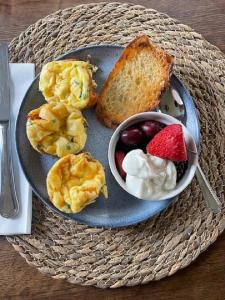 a plate of breakfast foods with a bowl of fruit at Route3BnB in Shag Harbour