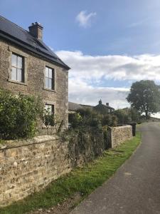 an old brick building with a road next to it at School House in Reeth