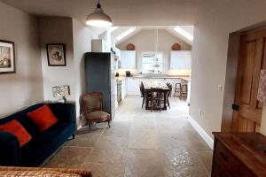 a living room with a blue couch and a kitchen at School House in Reeth +28 photos