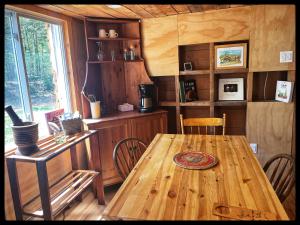 a dining room with a wooden table and chairs at gite comme un accord in Saint Mathieu Du Parc