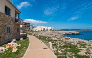 a path next to a building next to the water at Cielo Mar in S'Illot