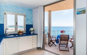 a kitchen with a table and a balcony with the ocean at Cielo Mar in S'Illot