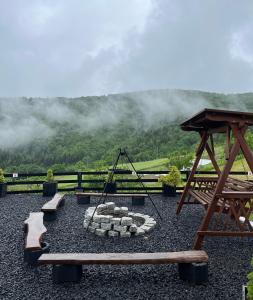 a playground with a swing and a fire pit at Domek w Chmurach II in Kicznia