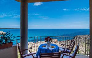 a table with a vase of flowers on a balcony with the ocean at Cielo Mar in S'Illot