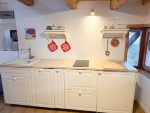 a kitchen with white cabinets and a sink at Holy View Apartment in Bolzano +33 photos