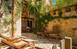 a patio with chairs and tables and a stone wall at La Casa De Los Espejos in Capdepera