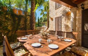 a wooden table with plates and napkins on a patio at La Casa De Los Espejos in Capdepera