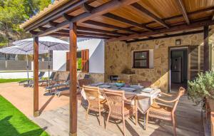 a patio with a table and chairs under a wooden pergola at Sa Gola in Canyamel