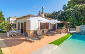 a house with a swimming pool and a patio with umbrellas at Sa Gola in Canyamel