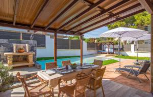 a patio with a table and chairs and an umbrella at Sa Gola in Canyamel