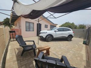 a white car parked in a backyard with a table and chairs at 22 On Schwester Frieda in Swakopmund