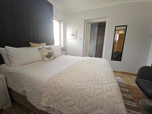 a bedroom with a large bed with white sheets at 22 On Schwester Frieda in Swakopmund