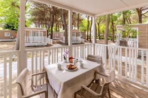 a table with a bowl of food on a porch at Club del Sole Le Gorette Cecina Easy Camping Village in Marina di Cecina