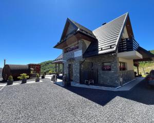 a small building with a roof on a gravel driveway at Domek w Chmurach II in Kicznia
