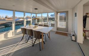 a dining room with a table and chairs and windows at 3 Bedroom Cozy Home In Haderslev in Haderslev