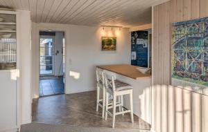 a small kitchen with a counter and a bar with stools at 3 Bedroom Cozy Home In Haderslev in Haderslev +14 photos