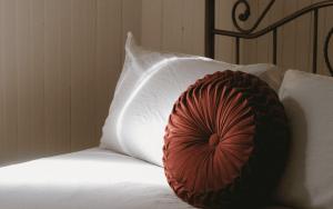 a red pillow sitting on top of a white pillow at Auberge des Korrigans in Stoneham