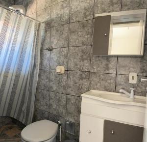 a bathroom with a toilet and a sink and a shower at Pousada Vila do Meio in Pinheiro +71 photos