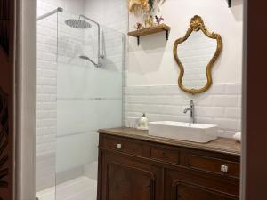 a bathroom with a sink and a shower with a mirror at Larbaud 6 - Hypercentre - Proche Thermes - Spacieux in Vichy