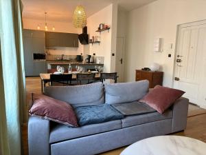 a living room with a blue couch and a kitchen at Larbaud 6 - Hypercentre - Proche Thermes - Spacieux in Vichy