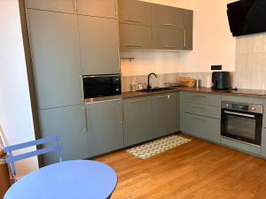 a kitchen with gray cabinets and a table and a table sidx sidx at Larbaud 6 - Hypercentre - Proche Thermes - Spacieux in Vichy +6 photos