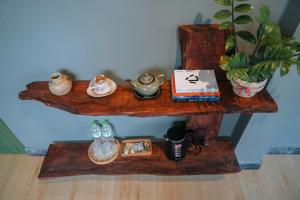 a wooden shelf with a tea set on it at Sita Home in Danang