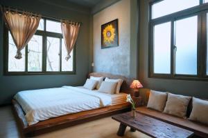 a bedroom with a large bed and a couch at Sita Home in Danang +8 photos