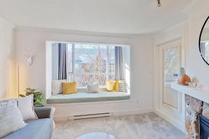 a living room with a window seat with yellow pillows at Town Plaza 427 in Whistler +13 photos