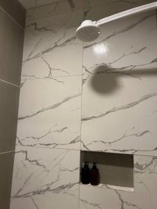 a bathroom with a white marble shower with a light at Suite Brisa da Colina in Garanhuns