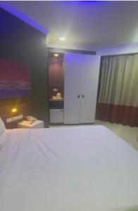 a bedroom with a large white bed and a kitchen at Nile Plaza Guest House in Aswān