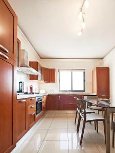 a kitchen with wooden cabinets and a table with chairs at Ivy in Is-Swieqi