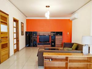 a living room with a couch and a tv at Ivy in Is-Swieqi