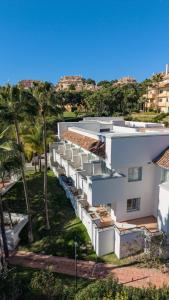 an aerial view of a white building with palm trees at Elviria Hills Living in Marbella