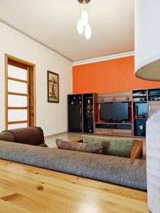 a living room with a couch and a tv at Ivy in Is-Swieqi