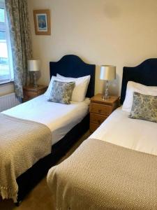 a bedroom with two beds and two lamps and a window at Seashore Lodge Guesthouse in Galway