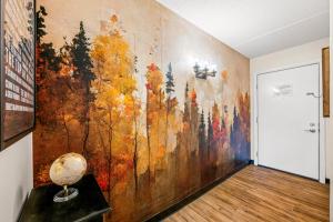 a large painting on a wall in a room with a floor at Stylish 1BR Free Attraction Tix Views! in Gatlinburg +8 photos
