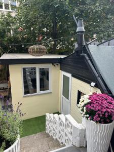 a small dog house with flowers in a yard at Tiny House Beachroom in Scheveningen