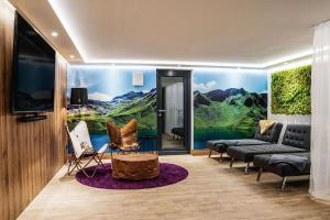a living room with a large painting on the wall at Chalet Amadeus by we rent in Piesendorf