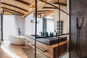 a bathroom with a tub and a sink and a bath tub at Chalet Amadeus by we rent in Piesendorf +50 photos